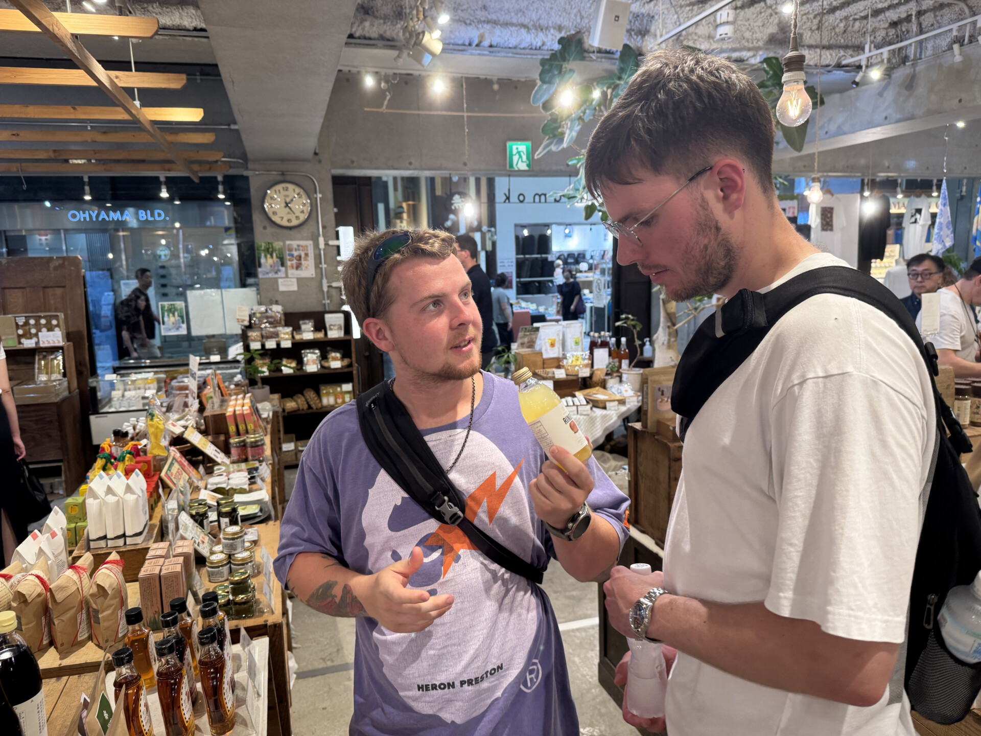Two visitors chatting inside a Kyoto specialty shop lined with shelves of local products